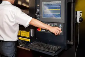 Automated workplace, engineer's hand on the working computer panel of industrial machinery